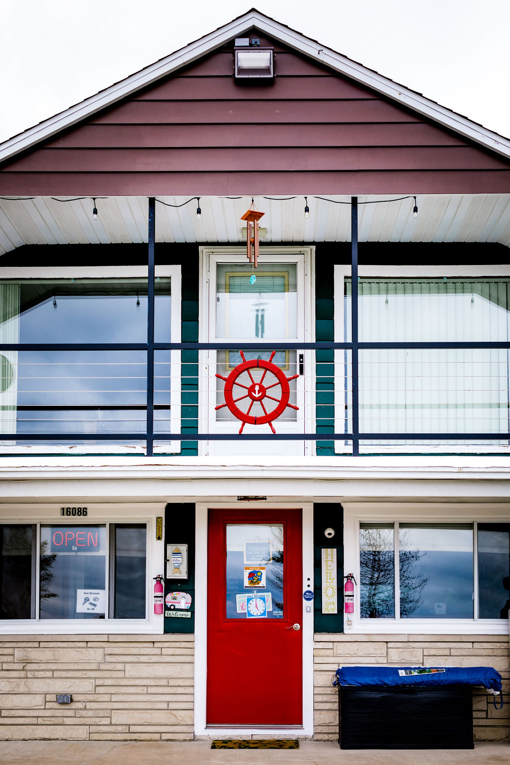 Front entrance of the lodge with red door and ship's wheel decor