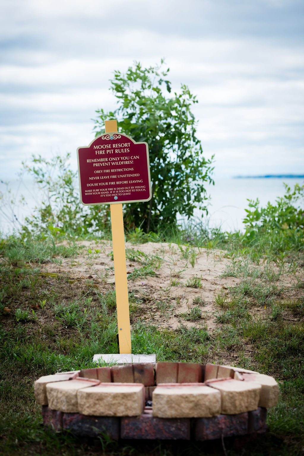 Moose Resort fire pit rules sign beside a brick fire ring