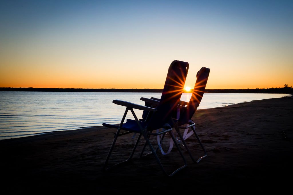 Two beach chairs at golden hour sunset on Lake Michigan