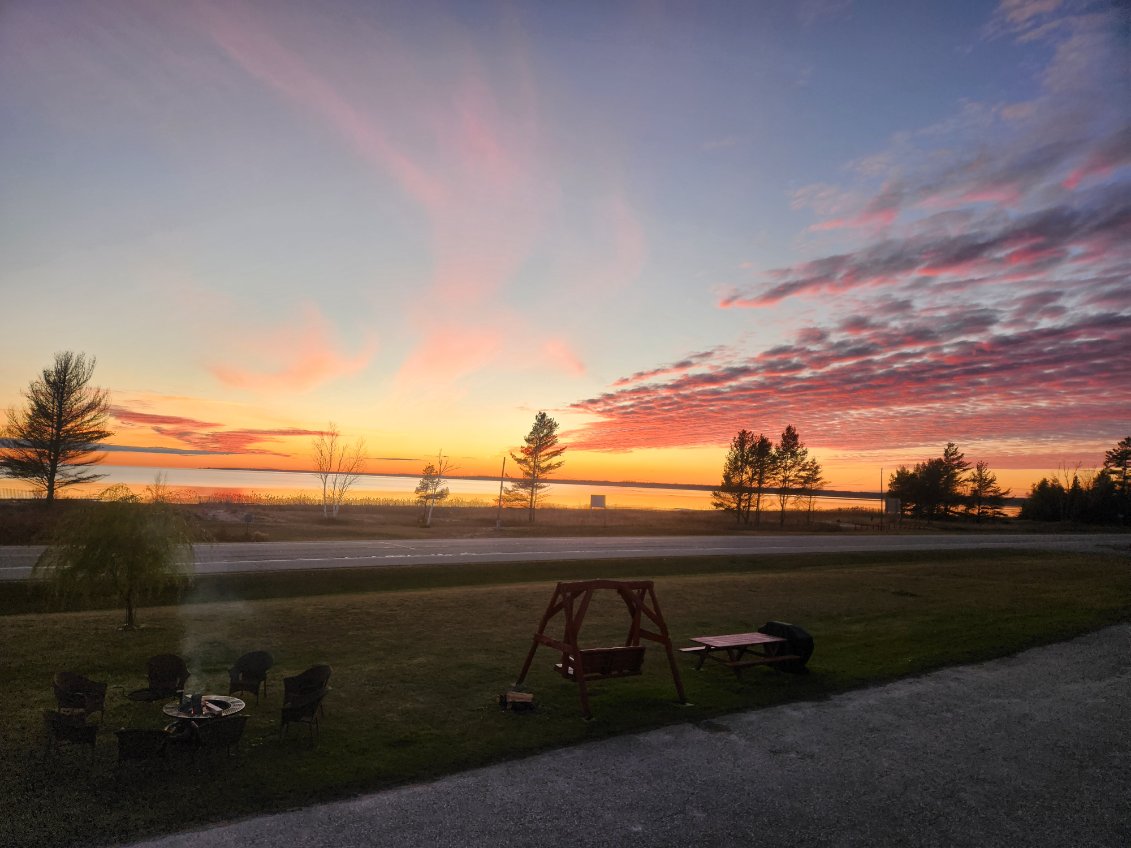 Pastel sunset over the lake with the lawn fire pit and swing in the foreground