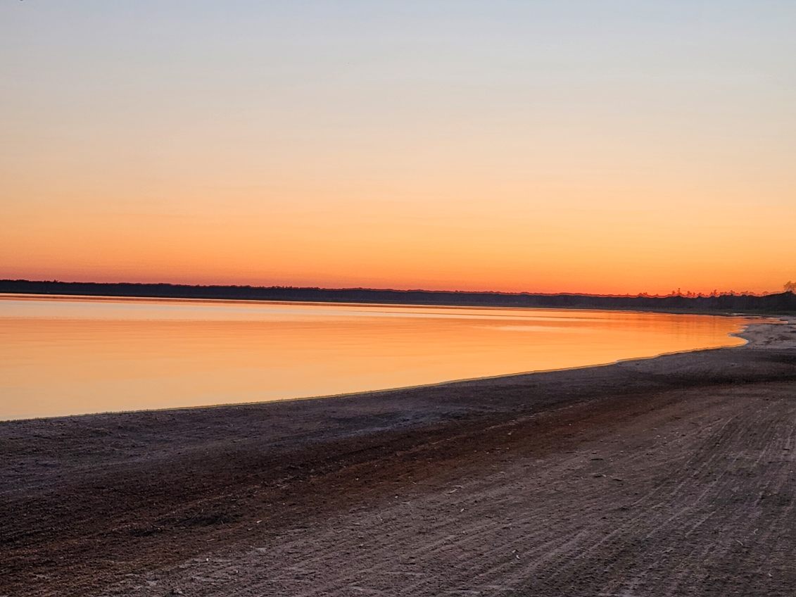 Soft orange afterglow reflecting on the still lake