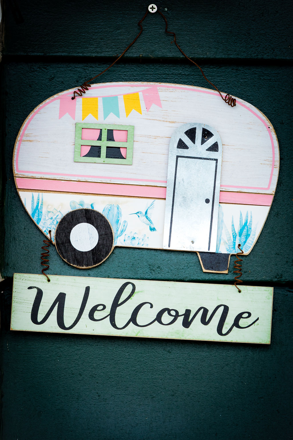 Vintage camper 'Welcome' sign on the green lodge door