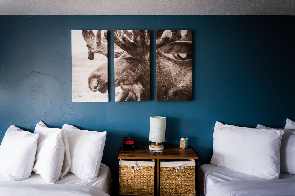 Close-up of sepia moose triptych above nightstand with woven baskets