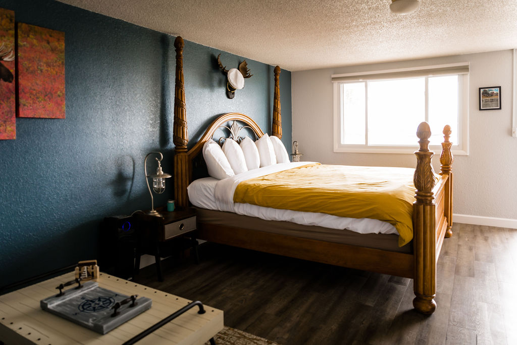 Four-poster king bed with lantern lamp and yellow accent throw