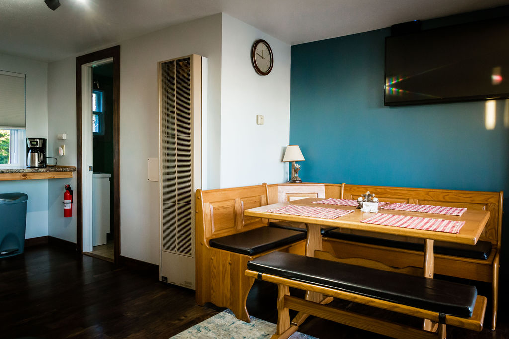Dining nook with checkered placemats and wall-mounted TV
